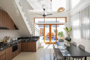 a kitchen with a table and chairs in a room at Villa OG Cruz in Canggu