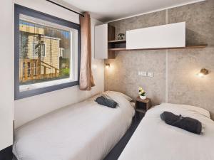 two beds in a room with a window at Le Coin Chill in Litteau +15 photos