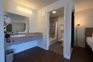 a bathroom with a sink and a toilet and a tub at Fisherman's Cove Inn in Monterey