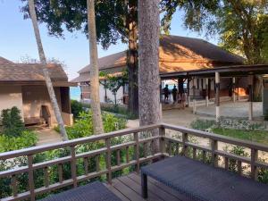 a wooden fence with a bench in front of a building at Samed Amoris Resort & Pool Villas in Ko Samed