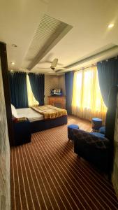 a hotel room with a bed and a couch at Hotel Five Rivers - 2 Min to Allama Iqbal International Airport, Lahore in Lahore +47 photos