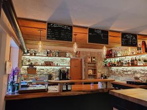 a bar with a counter and a shelf with alcohol at Casa Elena in Casso
