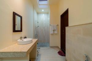 a bathroom with a sink and a shower at Umah Gatra Ubud in Ubud