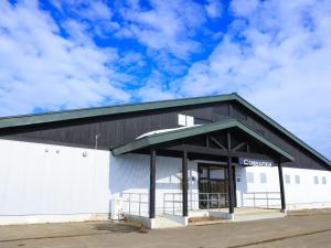 a large white building with a black roof at Cabin kutekun in Naka-shibetsu