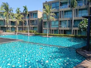 a large swimming pool in front of a building at Panwa Beach Side Beachfront in Panwa Beach