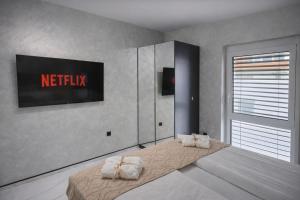 a bedroom with a bed with a television on the wall at DINLUX Luxury Apartment in Maribor