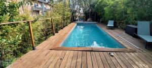 a small swimming pool on a wooden deck at Le coin tranquille in Rodez