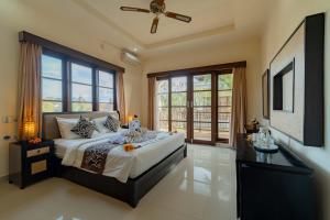 a bedroom with a large bed and a large window at Umah Gatra Ubud in Ubud