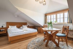 a bedroom with a bed and a table and chairs at Bloberger Hof in Salzburg