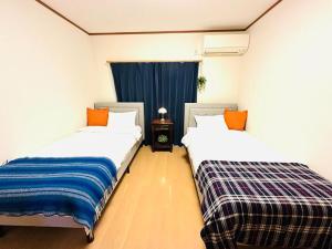 two beds sitting next to each other in a room at 清場Kiyoba in Kawaguchi