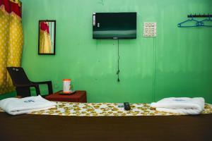 a green room with a bed with towels on it at Pandiyan guest house in Madurai