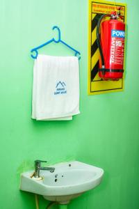 a bathroom with a sink and a towel and a fire hydrant at Pandiyan guest house in Madurai