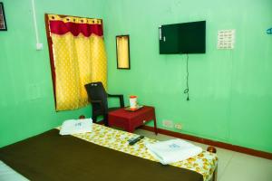 a hospital room with a bed and a chair at Pandiyan guest house in Madurai +57 photos
