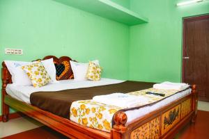 a bed in a room with green walls at Pandiyan guest house in Madurai