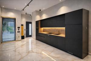 a kitchen with black cabinets and a sink at DINLUX Luxury Apartment in Maribor
