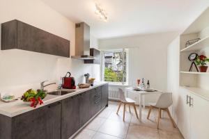 a kitchen with a sink and a table in it at Residenza La Serenata in Cavigliano