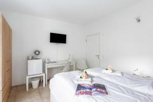 a white bedroom with a bed and a desk at Residenza La Serenata in Cavigliano