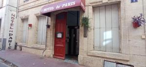 a red door on the side of a building at Hôtel de Paris - Narbonne in Narbonne