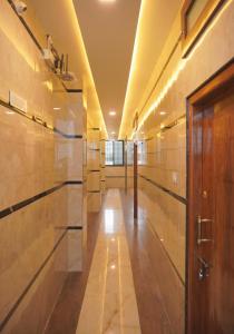 a hallway with marble walls and a wooden door at Dayanand Residency in Chitradurga