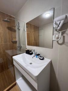 a bathroom with a white sink and a mirror at Orient Lux in Yakkasaray