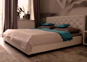 a bedroom with a white bed with blue pillows at Apartment Centrum number 8 in Poprad