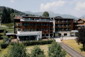 an apartment building with mountains in the background at Olimpionico Hotel in Castello di Fiemme