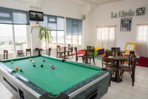 een pooltafel in een kamer met tafels en stoelen bij Hotel Paucam in Santa Teresita