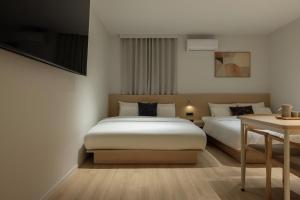 a hotel room with two beds and a table at Anook Hotel Jungangro Station in Daejeon +161 photos