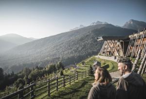 Ein Mann und eine Frau stehen auf einem Berggipfel in der Unterkunft Hotel Hubertus in Olang + 47 Fotos