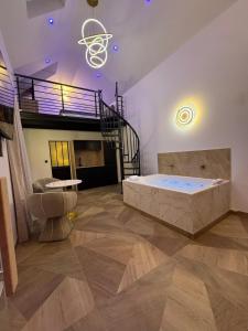 a large room with a bed and a staircase at Spa Signature in Dijon
