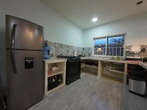 a kitchen with a stainless steel refrigerator and a counter at Casa ilusion Tuxpan Veracruz in Tampamachoco