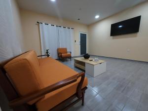 a living room with a couch and a tv at Casa ilusion Tuxpan Veracruz in Tampamachoco