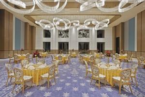 a banquet hall with tables and chairs and chandeliers at Fortune Select Siliguri- Member ITC Hotels' Group in Siliguri