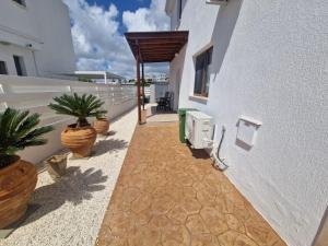 a patio with potted plants on the side of a building at Marmario Villa 10 in Anarita