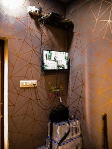 a room with a wall with a tv and a purse at Hotel GK Lodging & Boarding in Khāpri