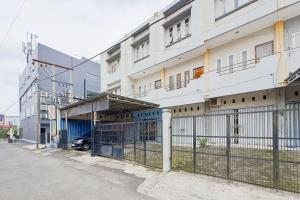 a building with a fence in front of it at RedDoorz at Arca Hostel Lampung in Lampung