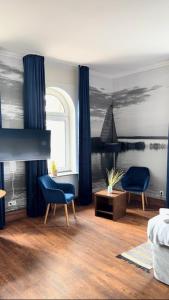 a bedroom with two chairs and a bed and a window at Hotel Marín in Steinhude