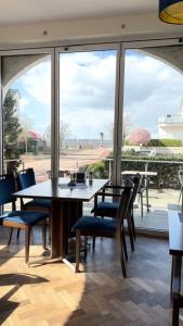 a dining room with a table and chairs and a large window at Hotel Marín in Steinhude