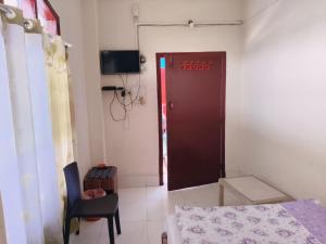 a room with a door and a bed and a chair at Hotel Silver Dragon, NK Darranga in Darranga