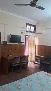 a room with a bed and a desk and a television at Hotel Silver Dragon, NK Darranga in Darranga +9 photos