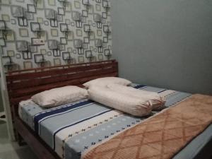 a bed with two pillows on top of it at Gallendra Villa in Karangploso