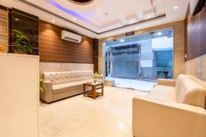 a living room with a couch and a table at Velocity Corporate Hotel TERMINAL 2,3 Delhi Airport With- Free Airport Pickup in New Delhi