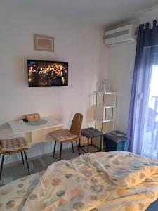 a bedroom with a bed and a table and chairs at Jozić Sobe Studio in Krk