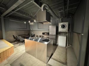 a kitchen with a stainless steel sink and a microwave at 5名様まで宿泊可能 四万十市下田の一棟貸し宿 明の宿 akari in Shimanto
