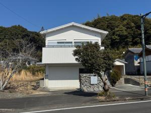 a white house on the side of a street at 5名様まで宿泊可能 四万十市下田の一棟貸し宿 明の宿 akari in Shimanto