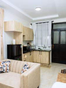 a living room with a couch and a kitchen at Epitome Luxe Homes near UN Gigiri and Two Rivers Mall in Ruaka