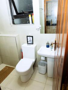 a bathroom with a toilet and a sink at Epitome Luxe Homes near UN Gigiri and Two Rivers Mall in Ruaka