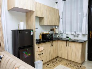 a kitchen with a black refrigerator and a sink at Epitome Luxe Homes near UN Gigiri and Two Rivers Mall in Ruaka +34 photos