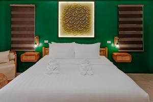 a bedroom with a large white bed with a green wall at Casa Verde Cliff Resort & Spa in Camotes Islands
