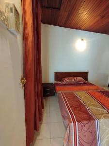 a bedroom with a bed and a red curtain at NS Apartments in Dalugama